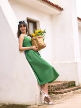 A lady wears a green midi dress.